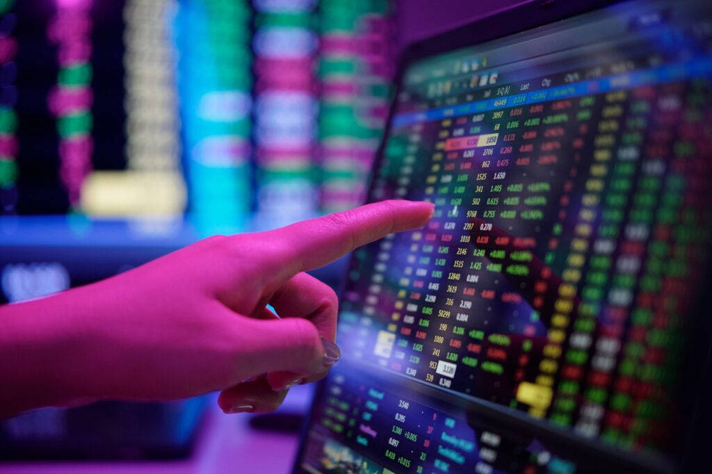 Finger Pointing at Stock Market Data on Monitor